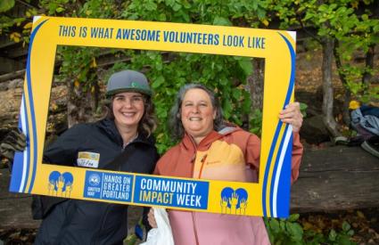 Two volunteers smile