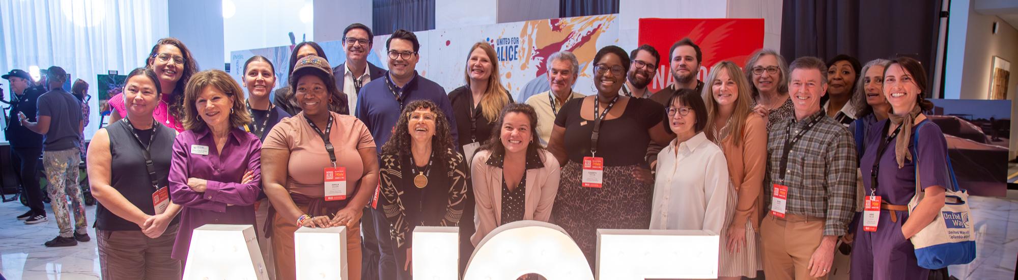 A large group of people pose and smile for the camera